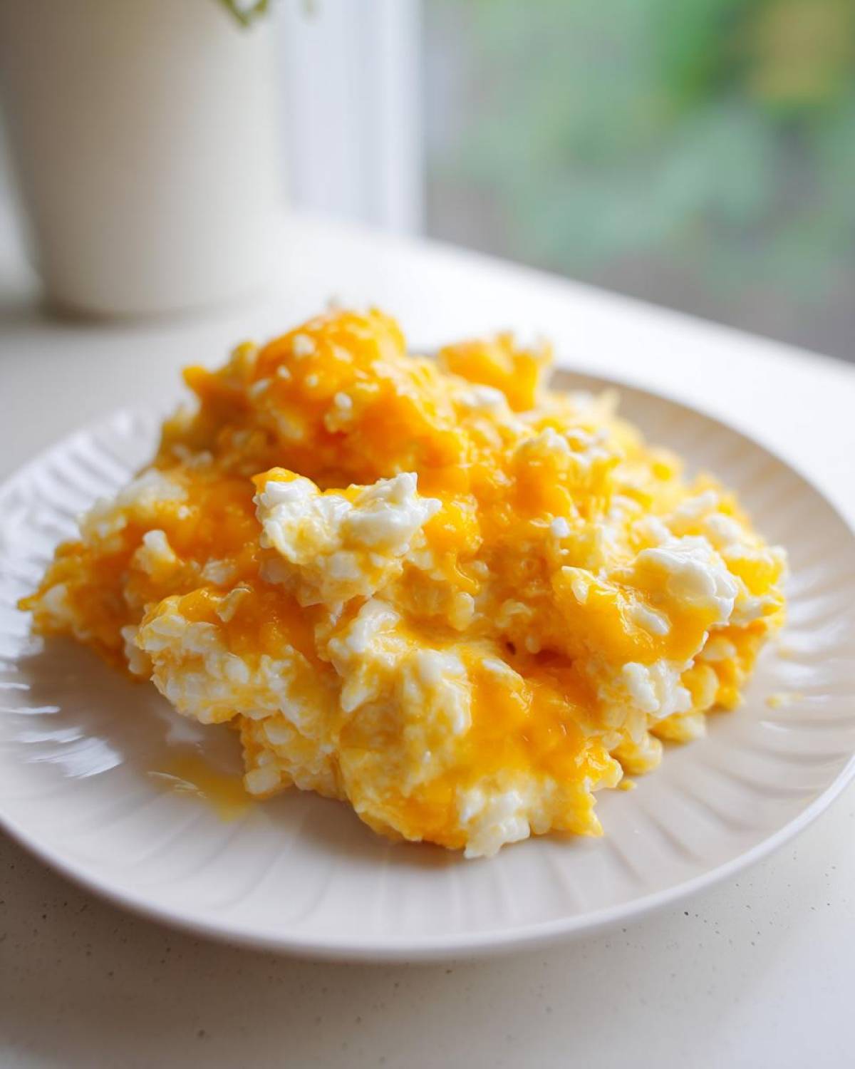 Close-up of a serving of cheesy rice, featuring white rice mixed with melted bright orange cheddar cheese.