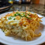 A square serving of creamy Monterey Chicken Spaghetti with a golden, melted cheese topping and green onion garnish.