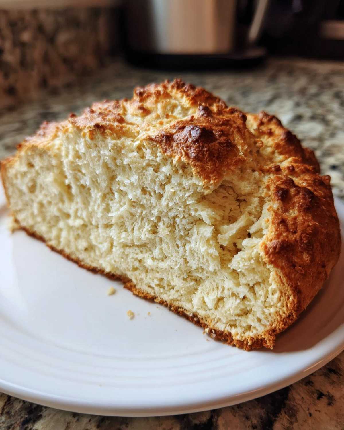 Close-up of a thick slice of homemade soda bread showing its fluffy interior and golden crust.