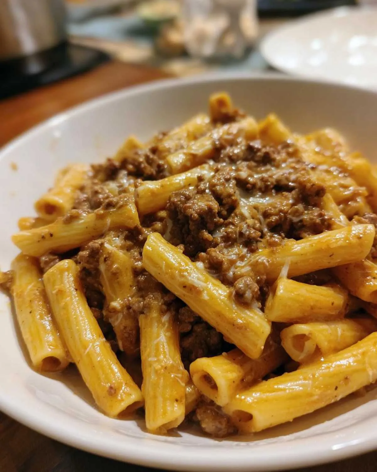 Close-up of creamy beef pasta made with rigatoni noodles and ground beef sauce, topped with melted cheese.