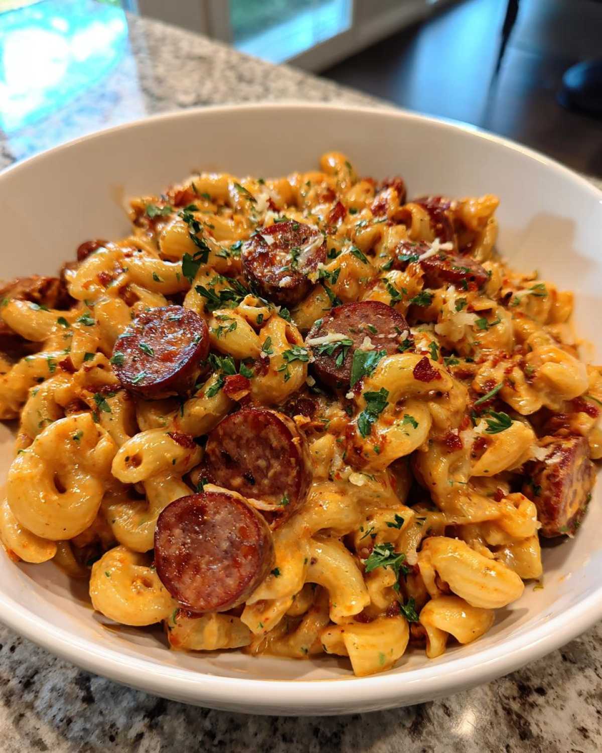 Close-up of creamy cajun sausage pasta with sliced andouille sausage, garnished with parsley.