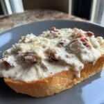 Close-up of a thick slice of toasted bread generously topped with creamy chipped beef on toast sauce and cheese.