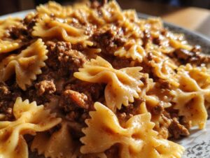 Close-up of creamy parmesan garlic beef bowtie pasta coated in a rich, savory sauce.