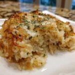 Close-up of a serving of french onion butter rice topped with melted cheese and parsley.
