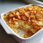 A creamy, baked hot chicken salad casserole topped generously with golden, crunchy cornflakes.