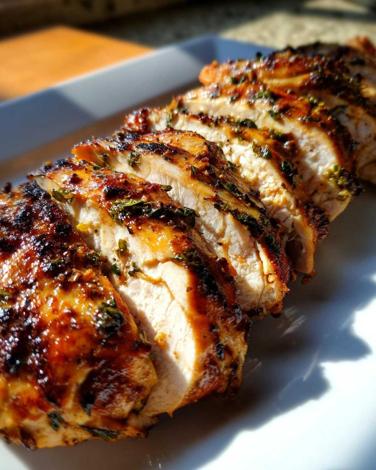 Close-up of perfectly cooked, sliced chicken breast showing juicy white meat and a flavorful herb chicken marinade glaze.