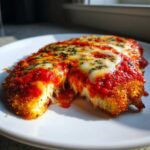 Close-up of keto chicken parmesan showing melted mozzarella cheese and rich tomato sauce.