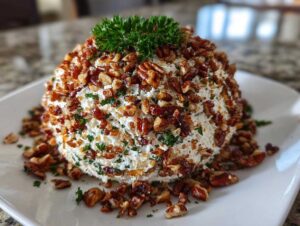 A creamy cheese ball recipe coated generously with chopped pecans and topped with fresh parsley.