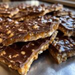 Close-up of stacked pieces of saltine cracker toffee showing the layers of cracker, caramel, and chocolate topping.
