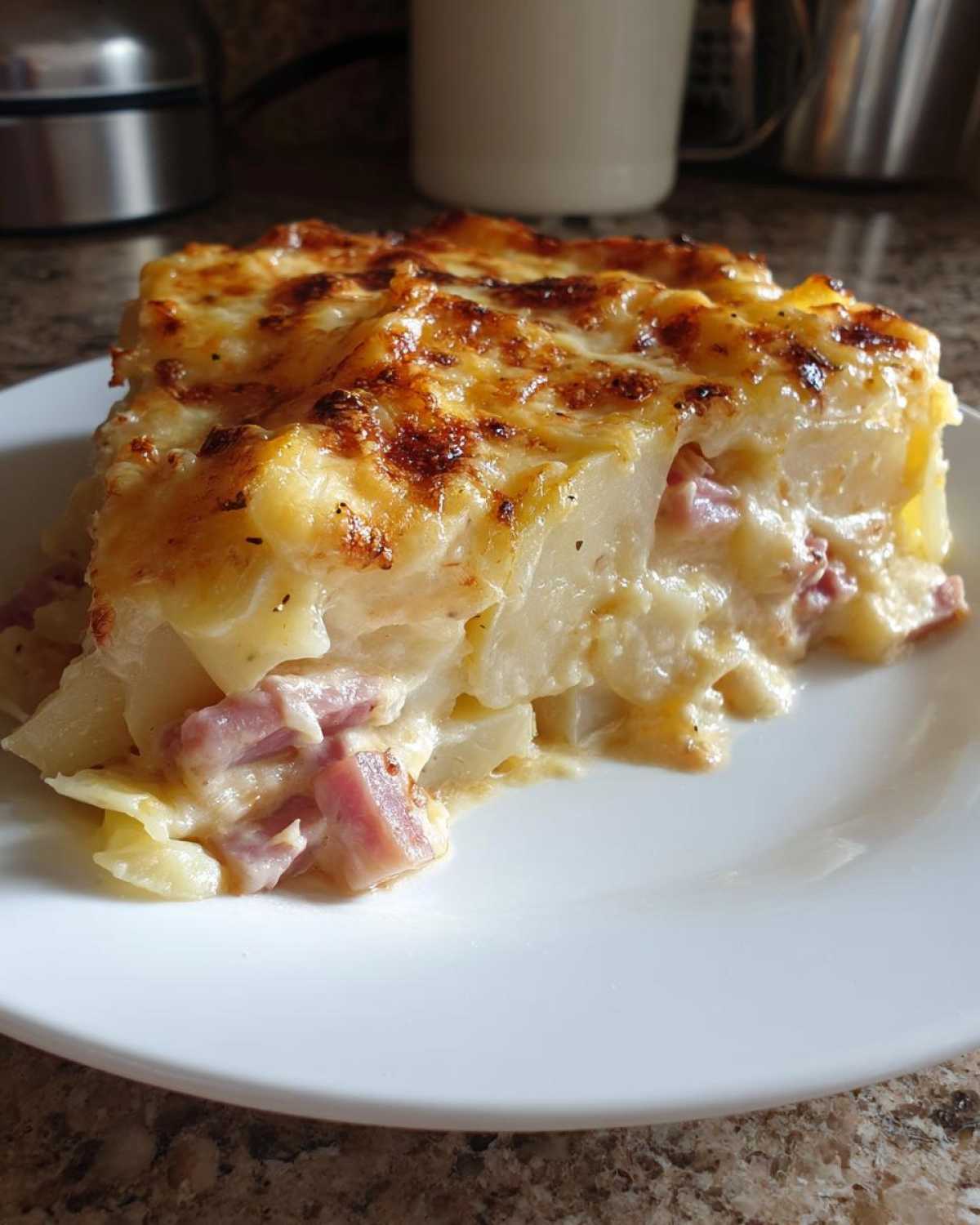 A generous slice of creamy scalloped potatoes and ham with a golden, bubbly cheese crust.
