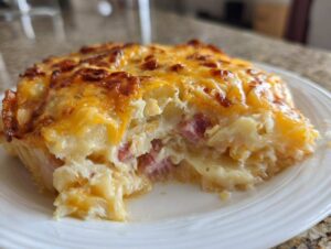 Close-up of a creamy slice of scalloped potatoes and ham topped with melted, browned cheese.