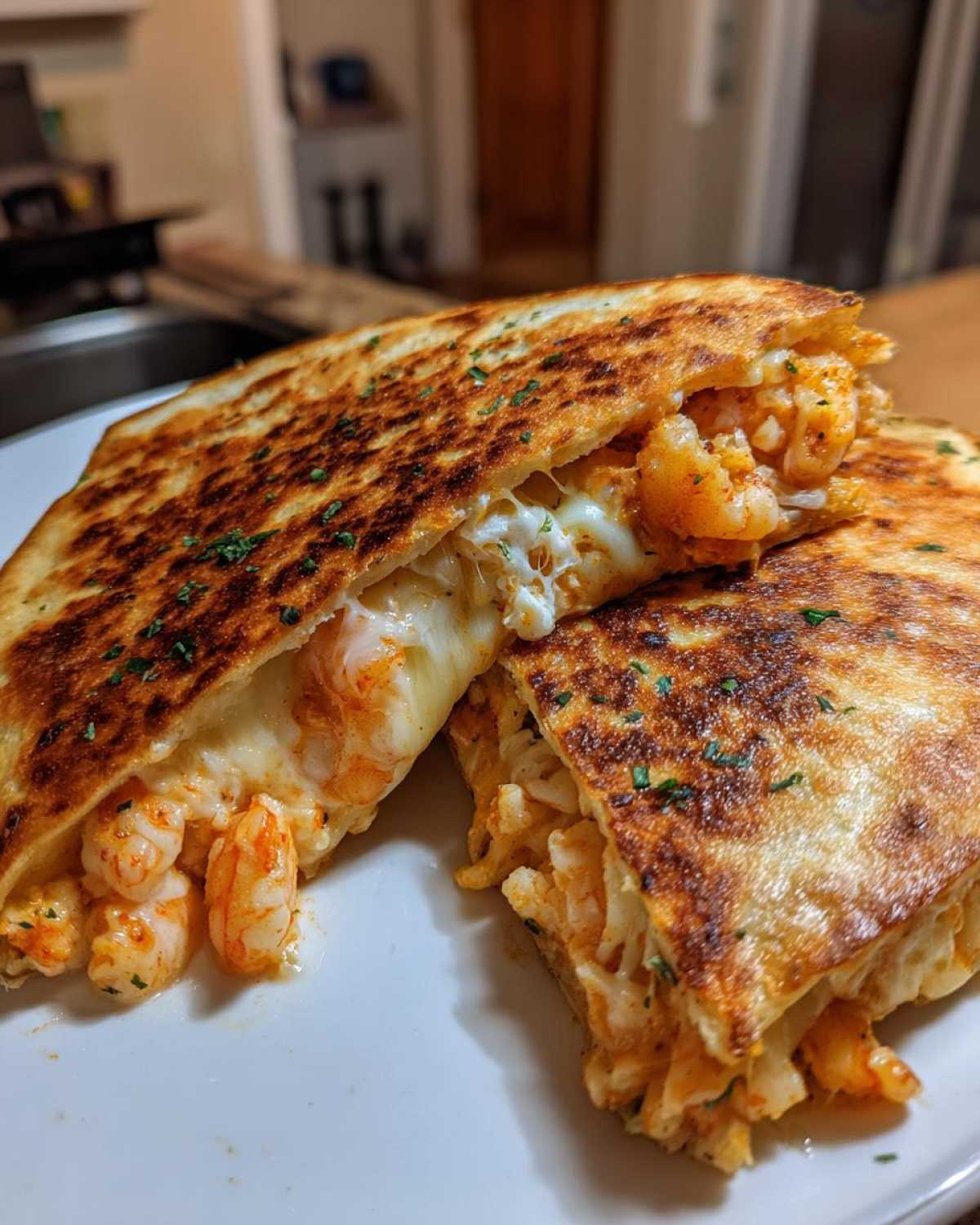 Close-up of a perfectly grilled shrimp quesadilla cut in half, showing melted cheese and seasoned shrimp filling.