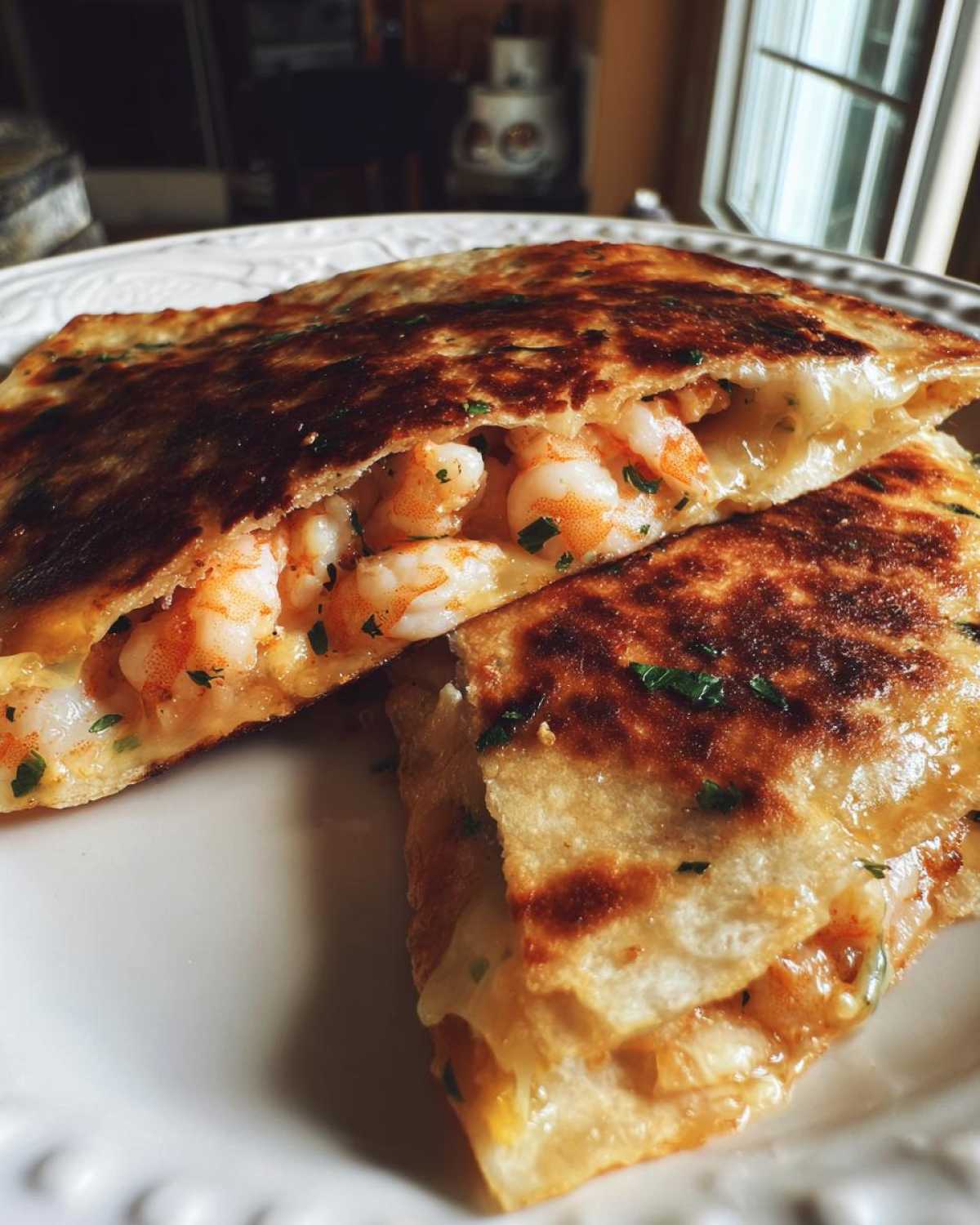 Close-up of a golden-brown shrimp quesadilla cut in half, revealing plump shrimp and melted cheese.