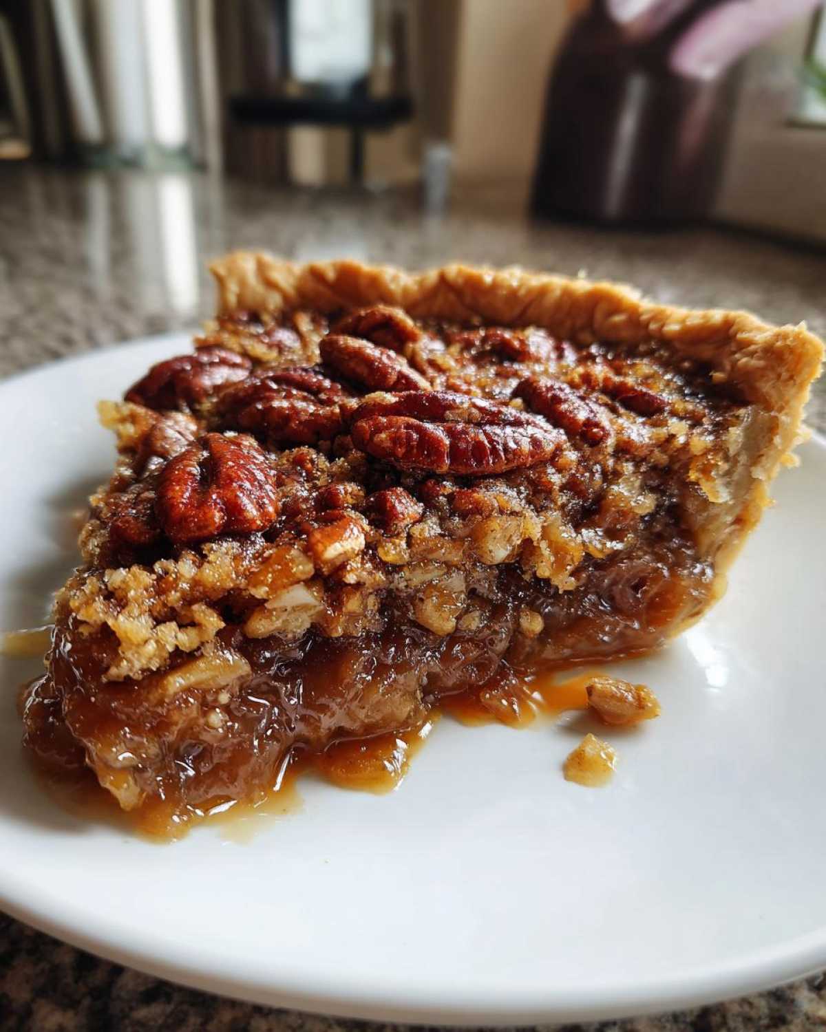 Close-up of a decadent slice of pecan pie cobbler recipe showing a gooey, caramelized filling and whole pecans on top.