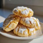 A stack of delicious, soft lemon crinkle cookies generously dusted with powdered sugar.