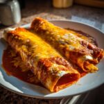 Two rolled cheese enchiladas covered in red sauce and melted orange and white cheese.
