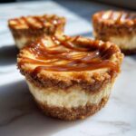 A close-up of one of the amazing cookie butter cheesecake cups, topped with a generous caramel drizzle.
