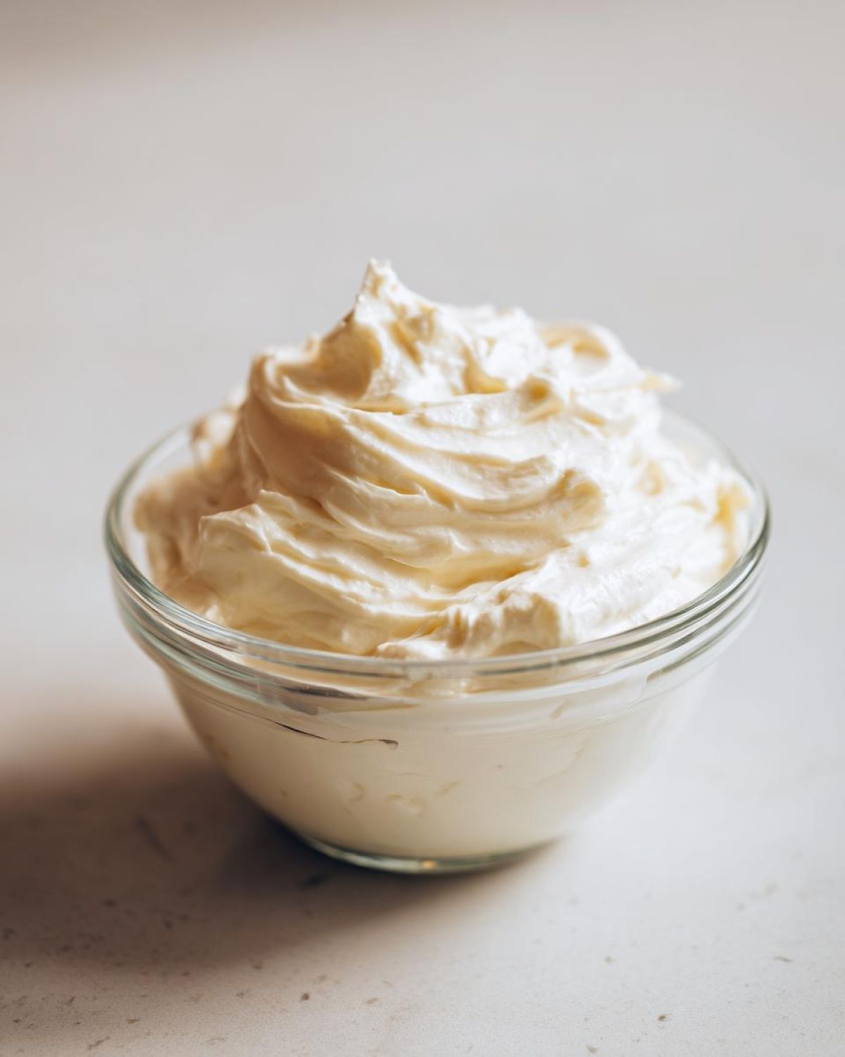 A small glass bowl filled with fluffy, creamy horseradish sauce, perfect for serving with beef.
