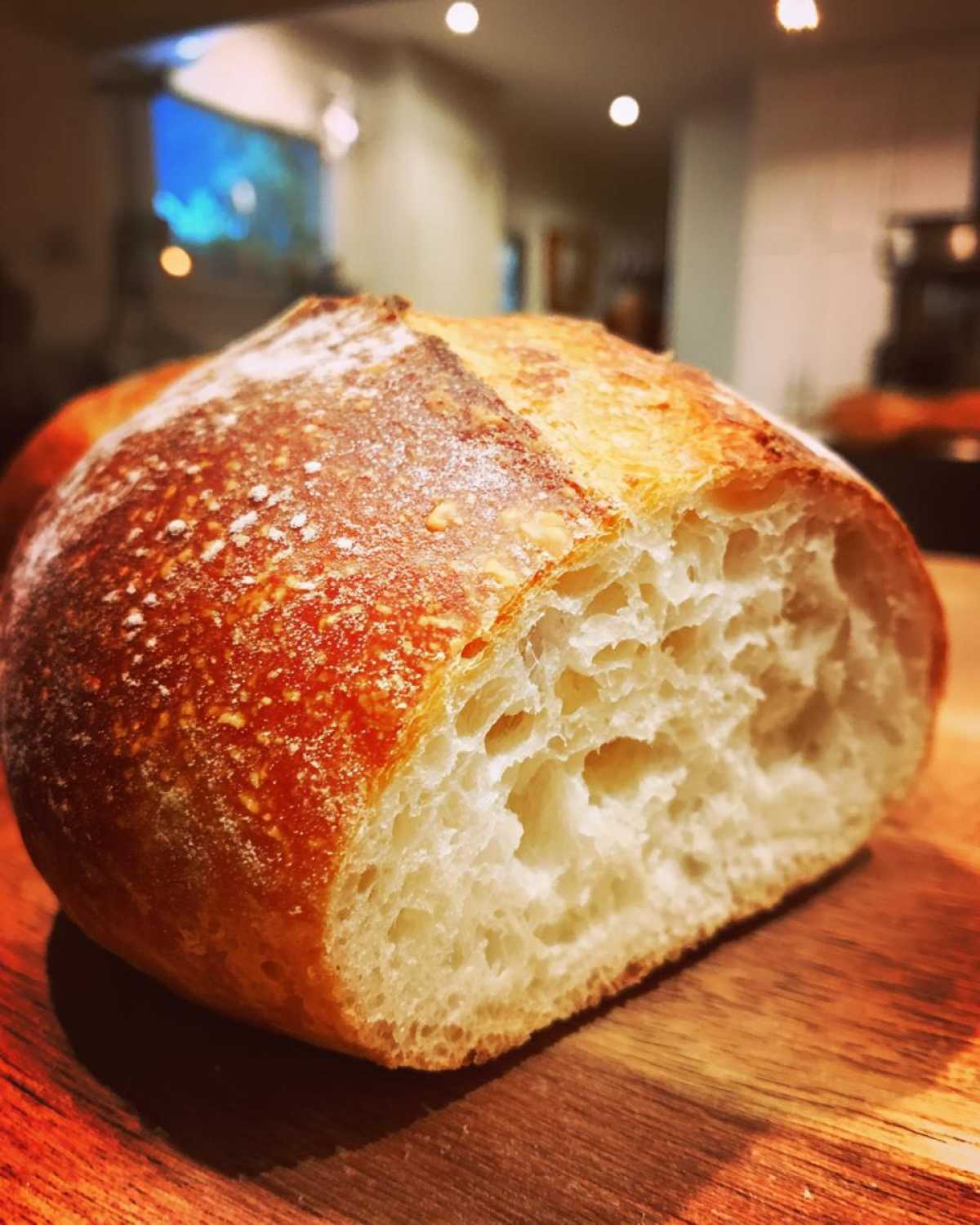 Close-up of a freshly baked loaf, cut open to show the airy crumb, perfect for making bread bowls.