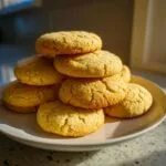 A tempting stack of freshly baked, golden sugar cookie treats piled high on a light plate.