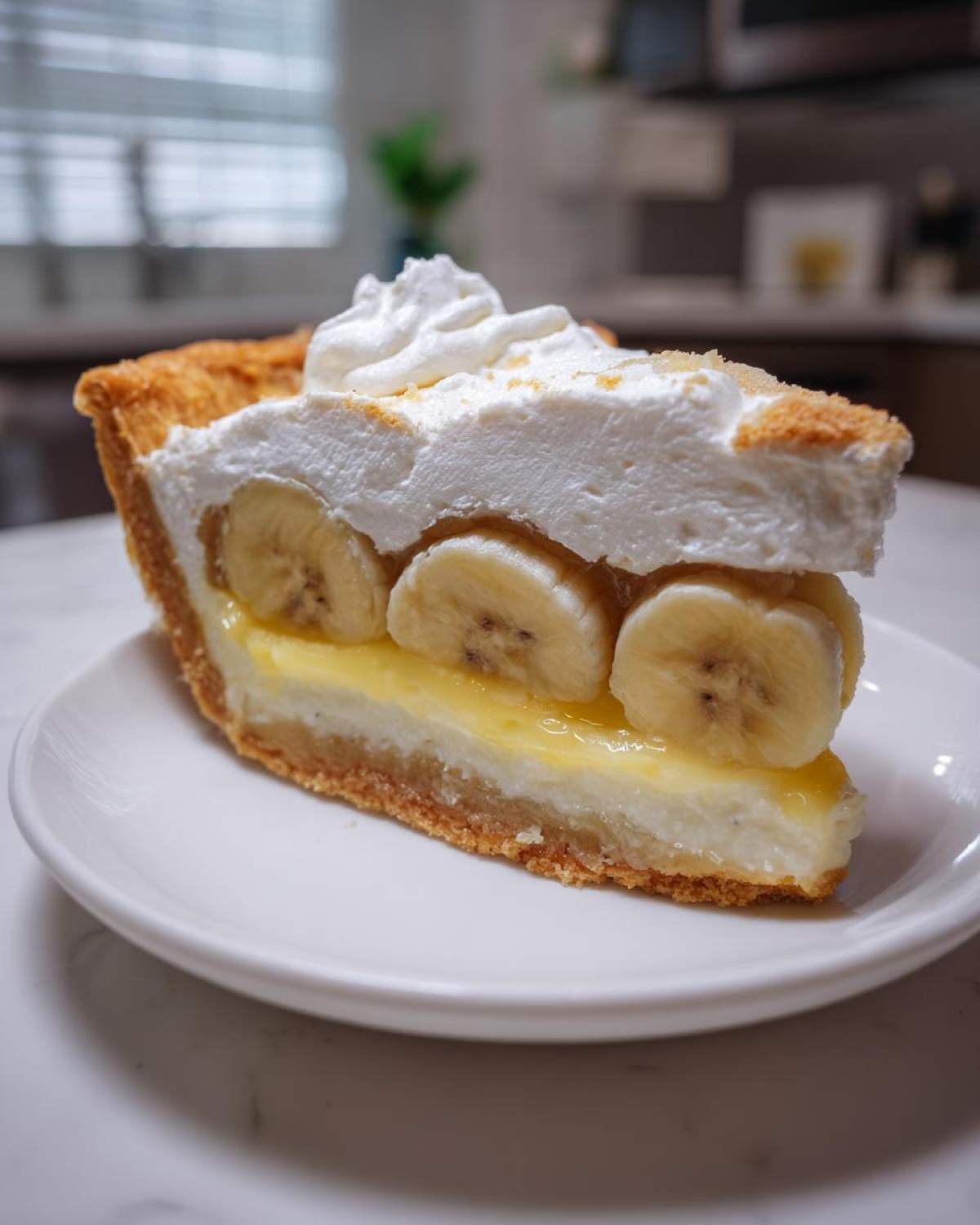 A perfect slice of amazing banana cream pie with layers of crust, custard, bananas, and whipped cream topping.