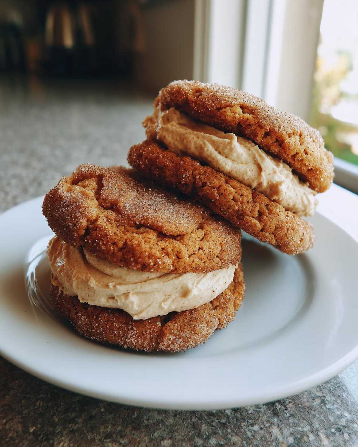 Two stacked churro cookies sandwiched together with a thick layer of cinnamon cream filling.
