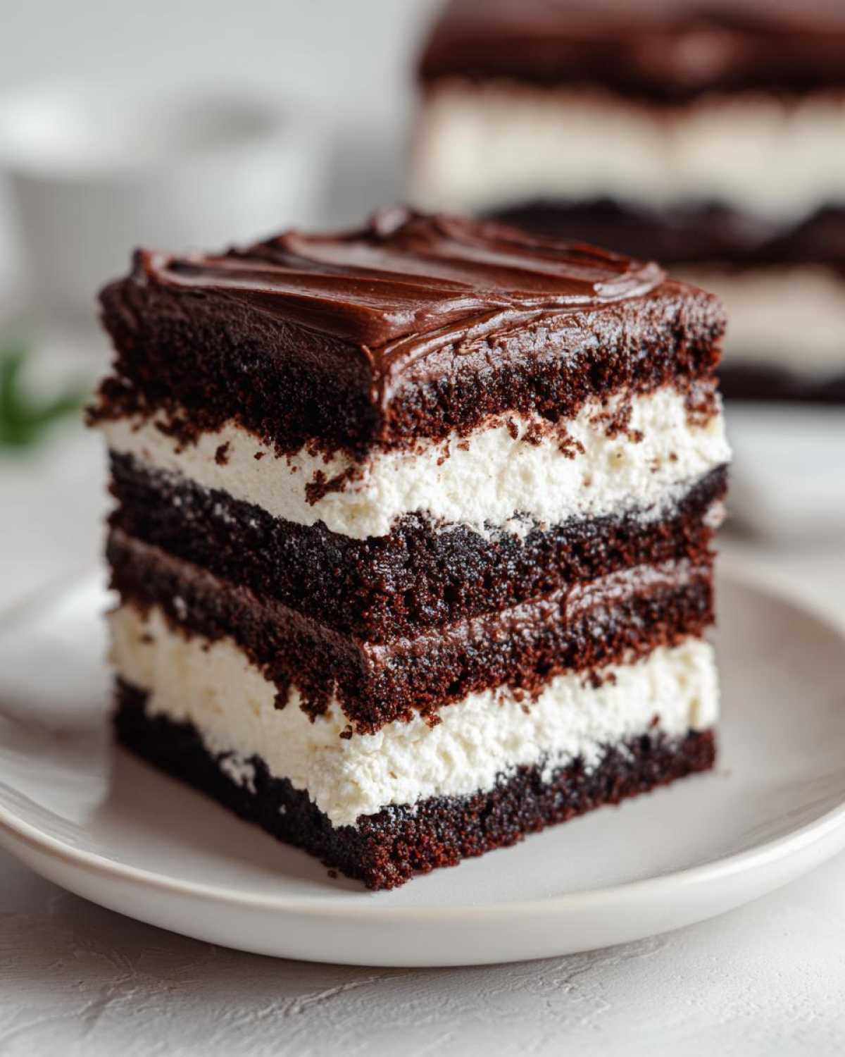 Close-up of a rich, layered slice of amazing italian love cake featuring dark chocolate cake and white cream filling.