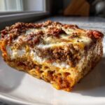 A rich, layered slice of baked ziti casserole with meat sauce and creamy ricotta cheese.