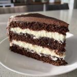Close-up of a decadent slice of chocolate Italian love cake with white cream filling layers.