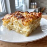 A perfect square slice of creamy potatoes au gratin with a golden-brown, cheesy top.