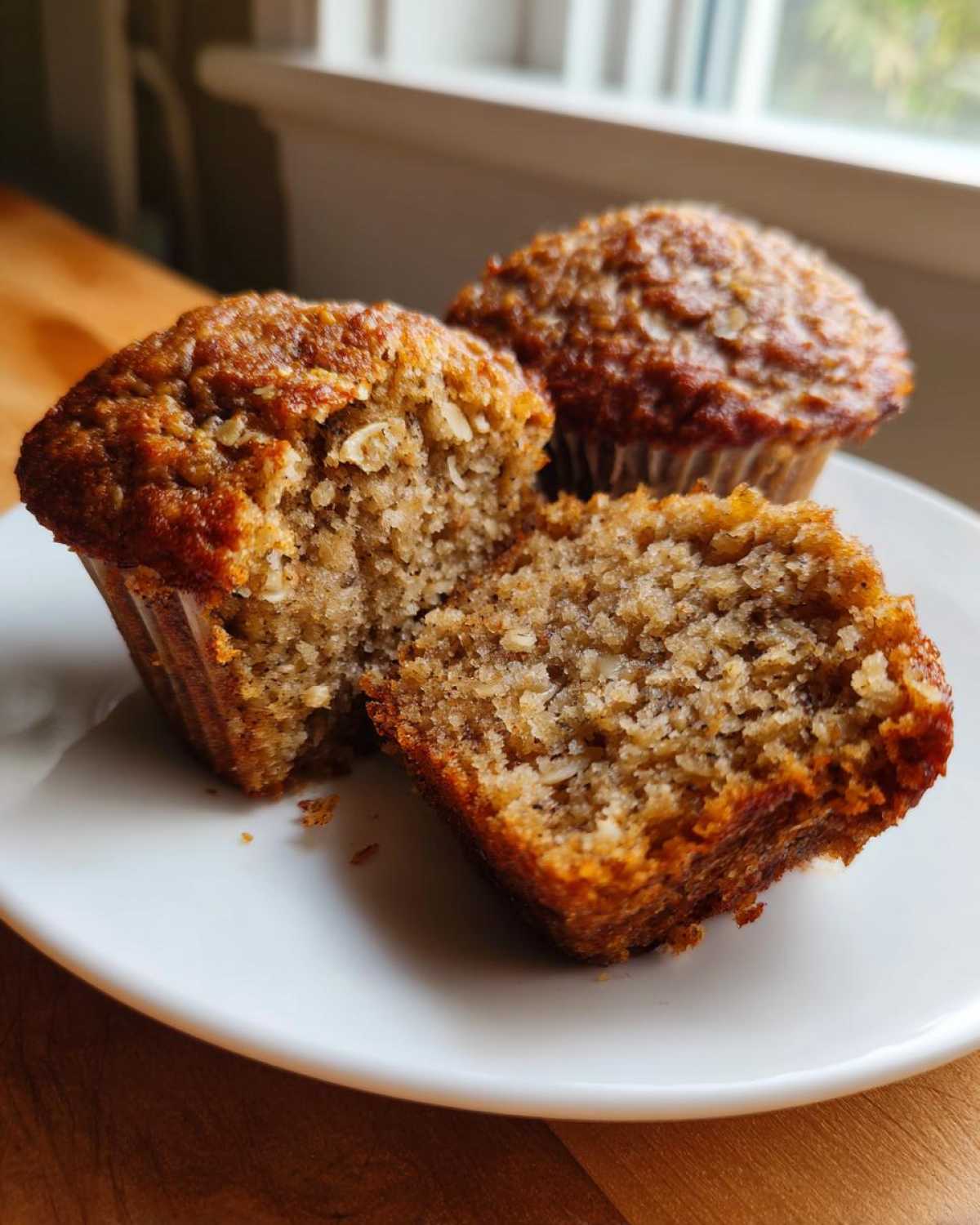 Close-up of a banana oatmeal muffin cut in half showing the moist, textured interior with visible oats.