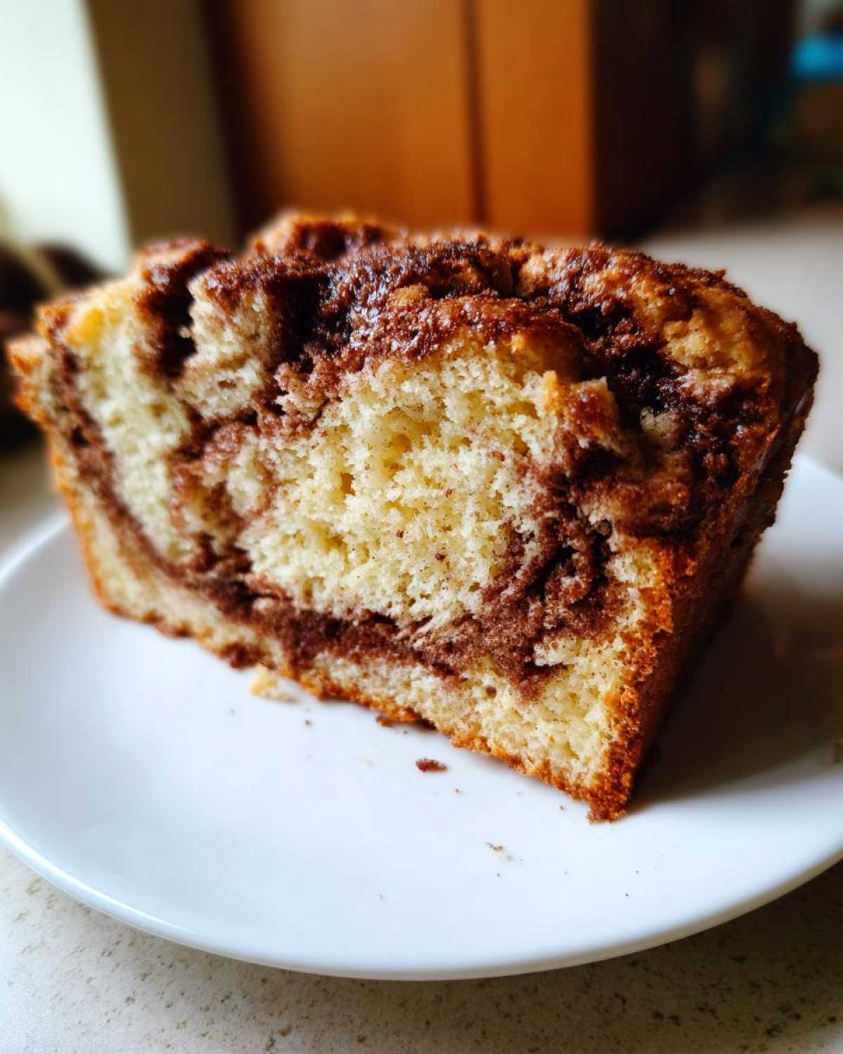 Close-up of a moist slice of cinnamon bread showing the swirl of cinnamon filling.