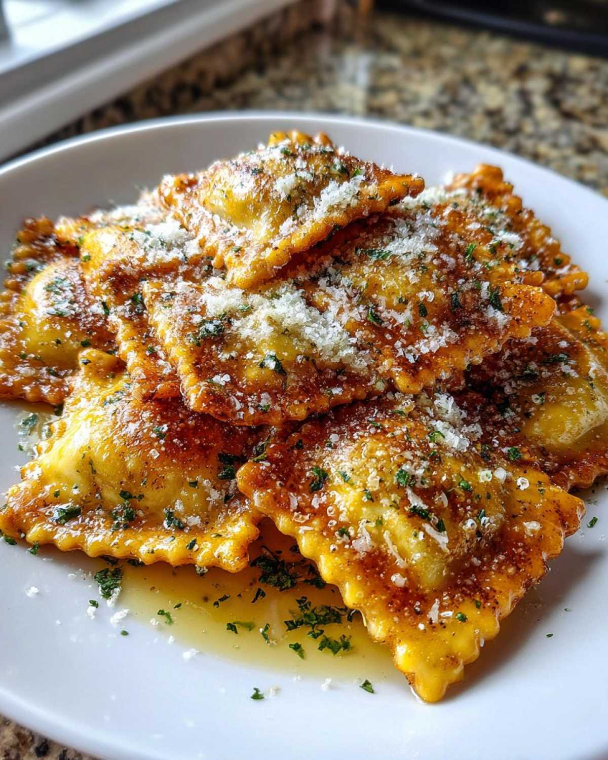 Close-up of crispy, golden air fryer cheesy ravioli topped with grated Parmesan cheese and parsley.