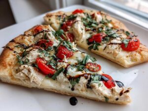 Two slices of amazing chicken caprese flatbread topped with mozzarella, tomatoes, basil, and balsamic glaze.