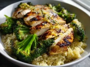 Close-up of sliced grilled chicken and charred broccoli served over quinoa in a white bowl, perfect for grilled chicken and broccoli bowls.