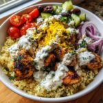 Close-up of mediterranean lemon-dill chicken bowls featuring grilled chicken, quinoa, and creamy dill sauce.
