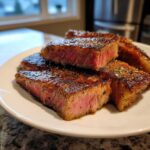 Close-up of perfectly seared and sliced steak pieces showing a medium-rare center, achieving melt-in-your-mouth steak texture.