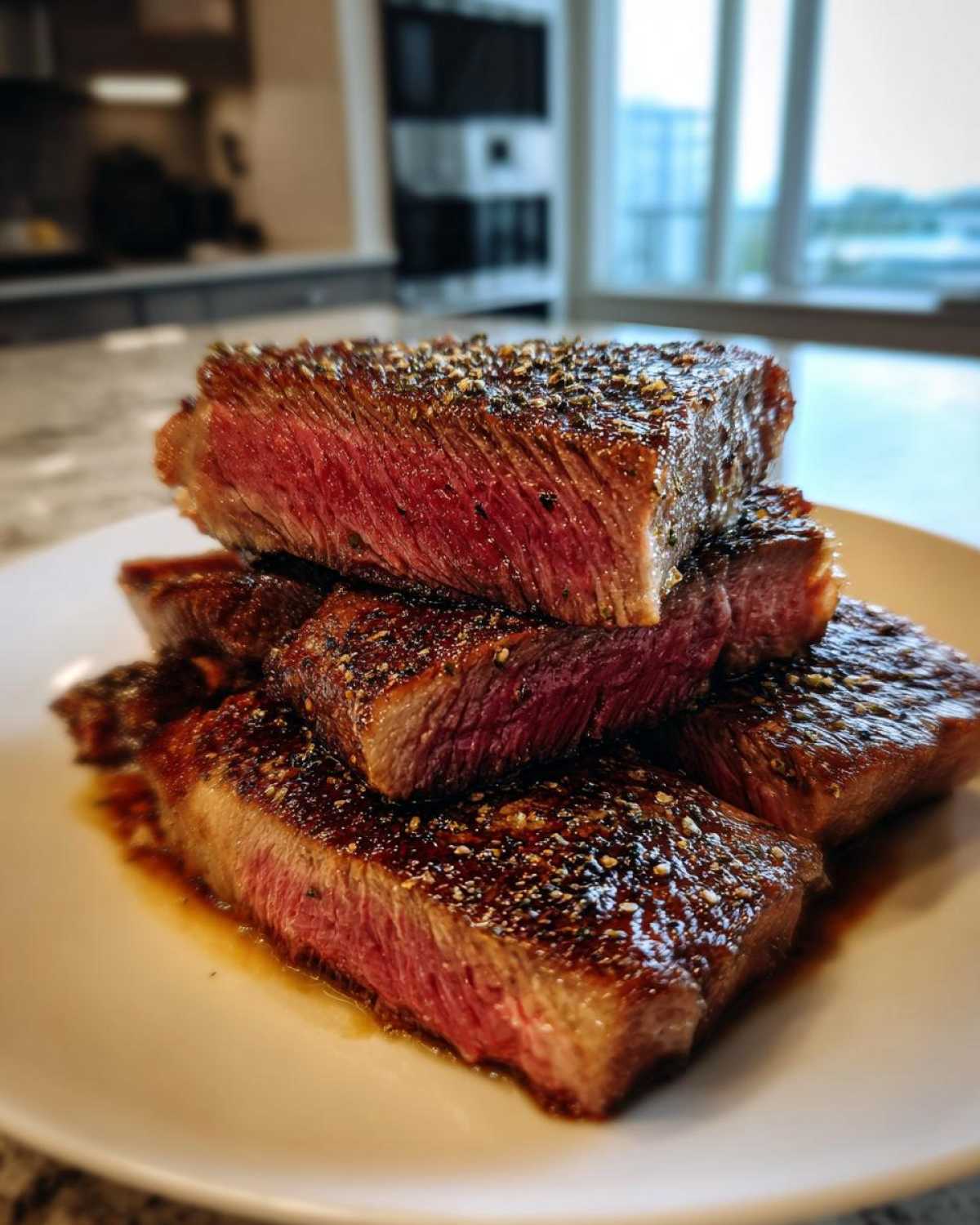 Stack of thick-cut steak slices showing a perfect medium-rare center, achieving melt-in-your-mouth steak texture.