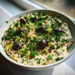 A creamy olive lovers dream dip topped with whole Kalamata olives, chopped parsley, and olive oil.
