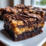 A rich, fudgy slice of Samoa brownies featuring a thick caramel-coconut layer and chocolate drizzle.