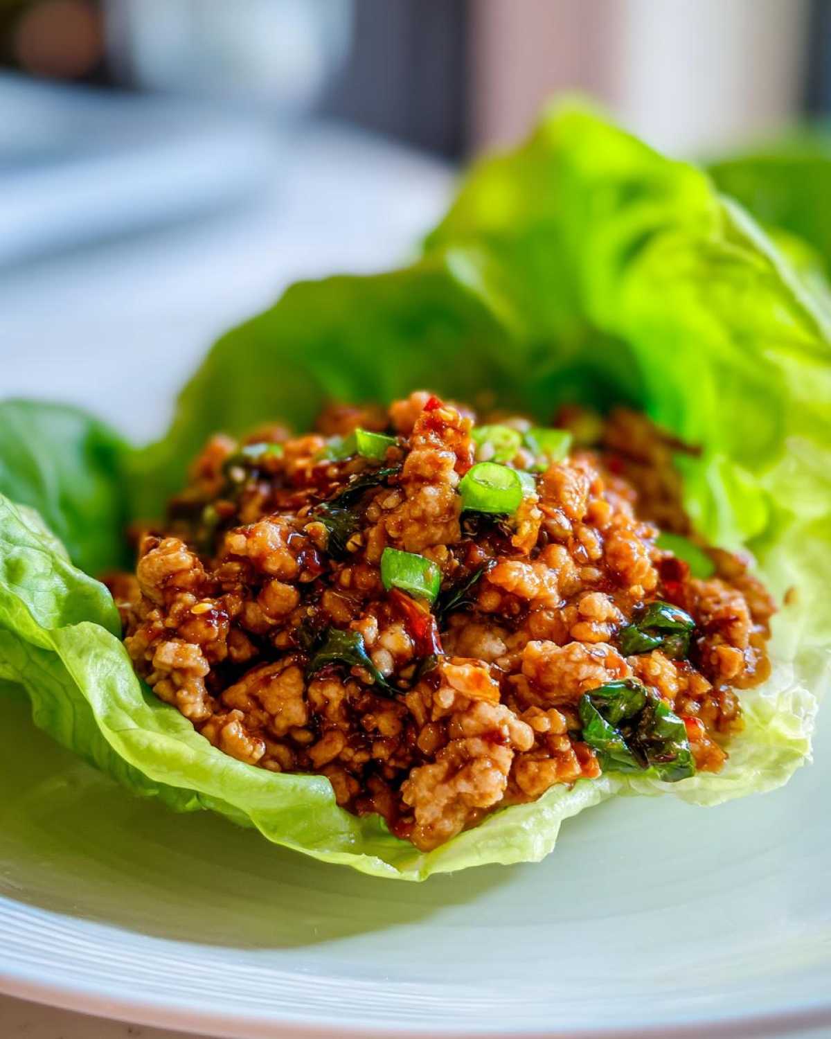 Close-up of savory ground chicken filling served in a crisp lettuce cup, perfect for chicken lettuce wraps.