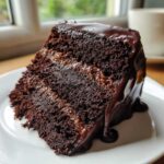 Close-up of a decadent slice of dubai chocolate cake with dark chocolate layers and a thick, dripping chocolate ganache.