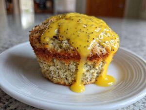 A close-up of an amazing Lemon poppy seed muffin topped with thick, bright yellow lemon glaze dripping down the sides.