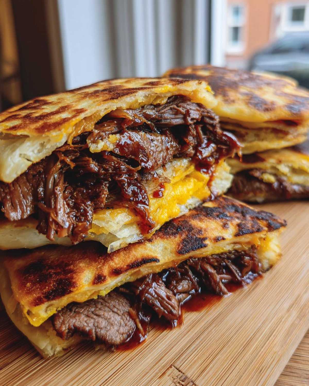Close-up of a delicious Dubai paratha smash burger cut in half, showing shredded saucy meat and melted cheese inside grilled paratha bread.