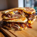 Two halves of a juicy Dubai paratha smash burger stacked, showing steak, melted cheese, and caramelized onions inside grilled paratha bread.