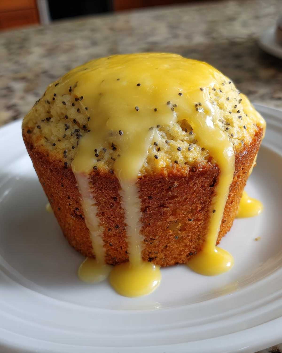 Close-up of a freshly baked Lemon poppy seed muffin topped with a thick, dripping yellow lemon glaze.