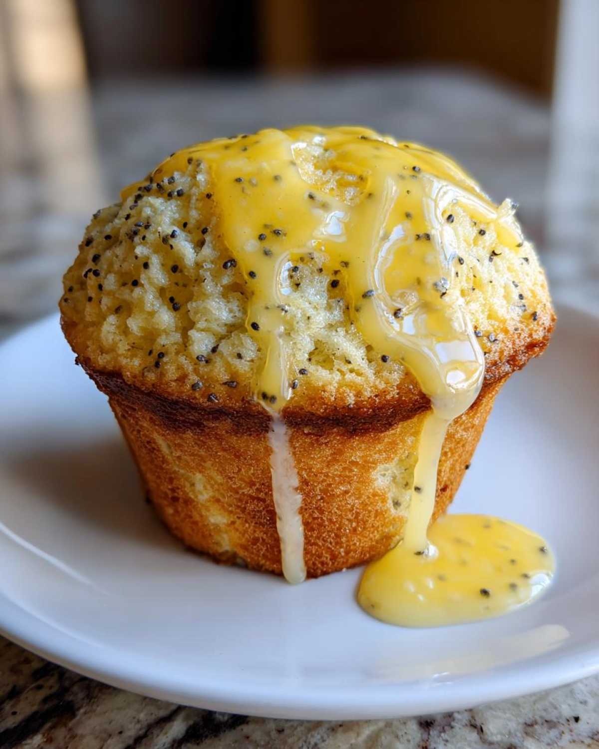 A single, golden Lemon poppy seed muffin topped with a thick, dripping lemon glaze speckled with poppy seeds.