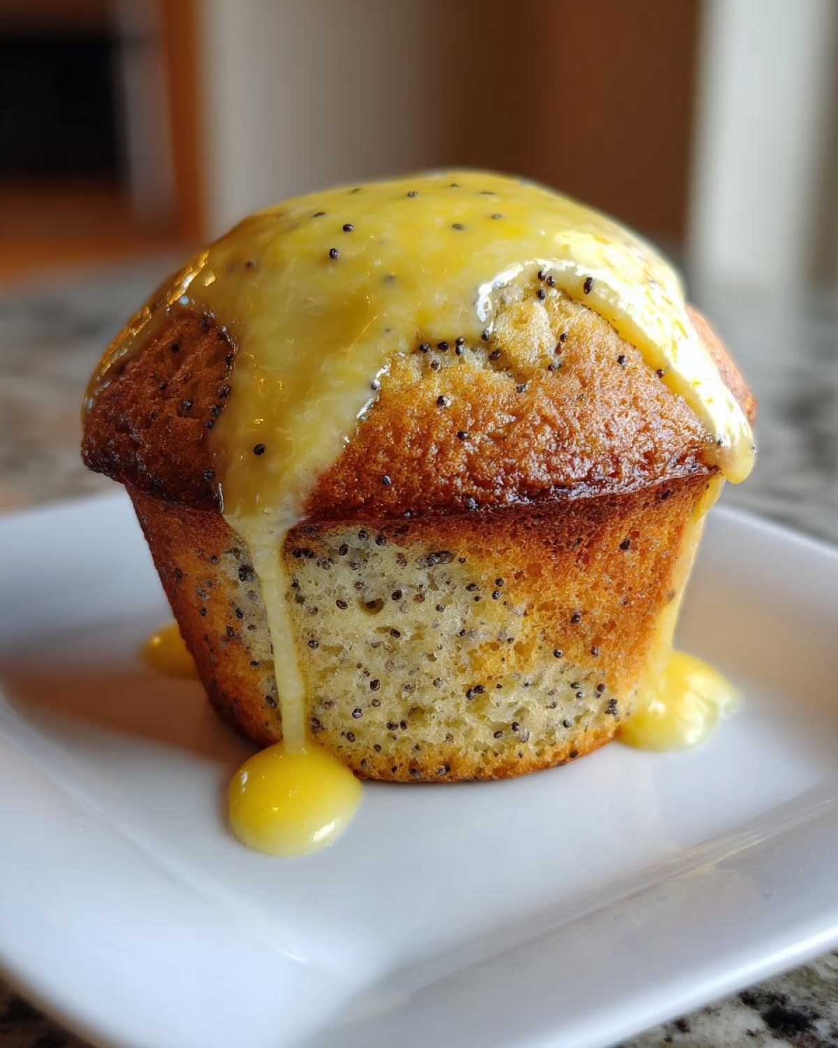 A close-up of a golden brown lemon poppy seed muffin topped with thick, dripping lemon glaze.
