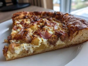 Close-up of a thick slice of sausage ricotta honey pizza showing the fluffy crust, creamy ricotta, sausage, and caramelized onions.
